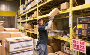 warehouse worker wearing voice headset picking grocery boxes